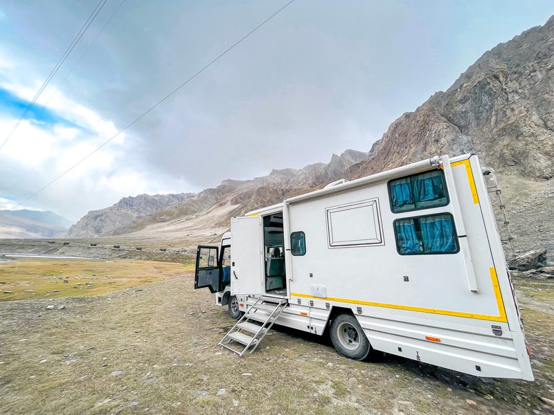 The Explorer caravan on a scenic green hill road