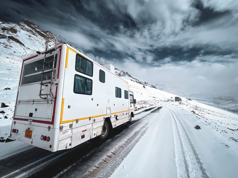 The Explorer caravan driving through snow on the Delhi to Ladakh route