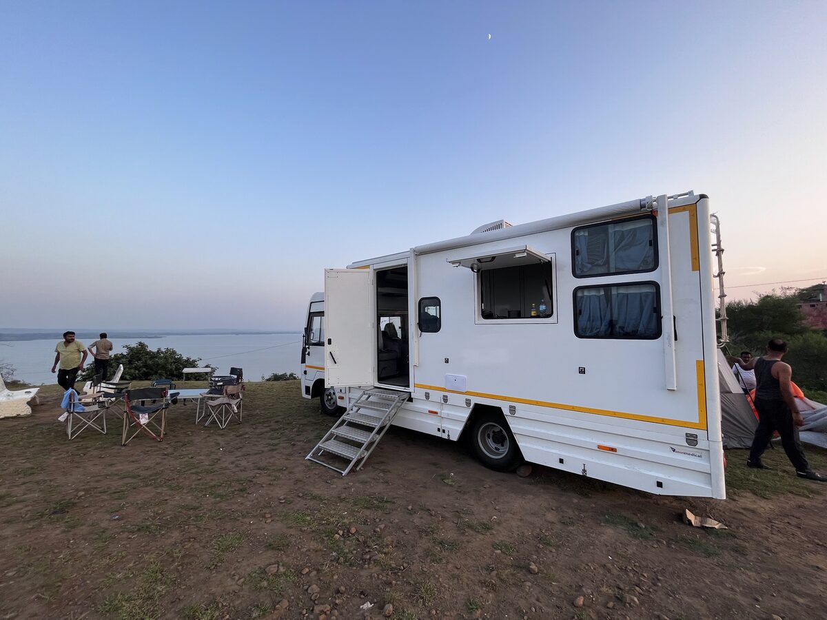 Guest taking in a wide Kerala landscape beside the caravan